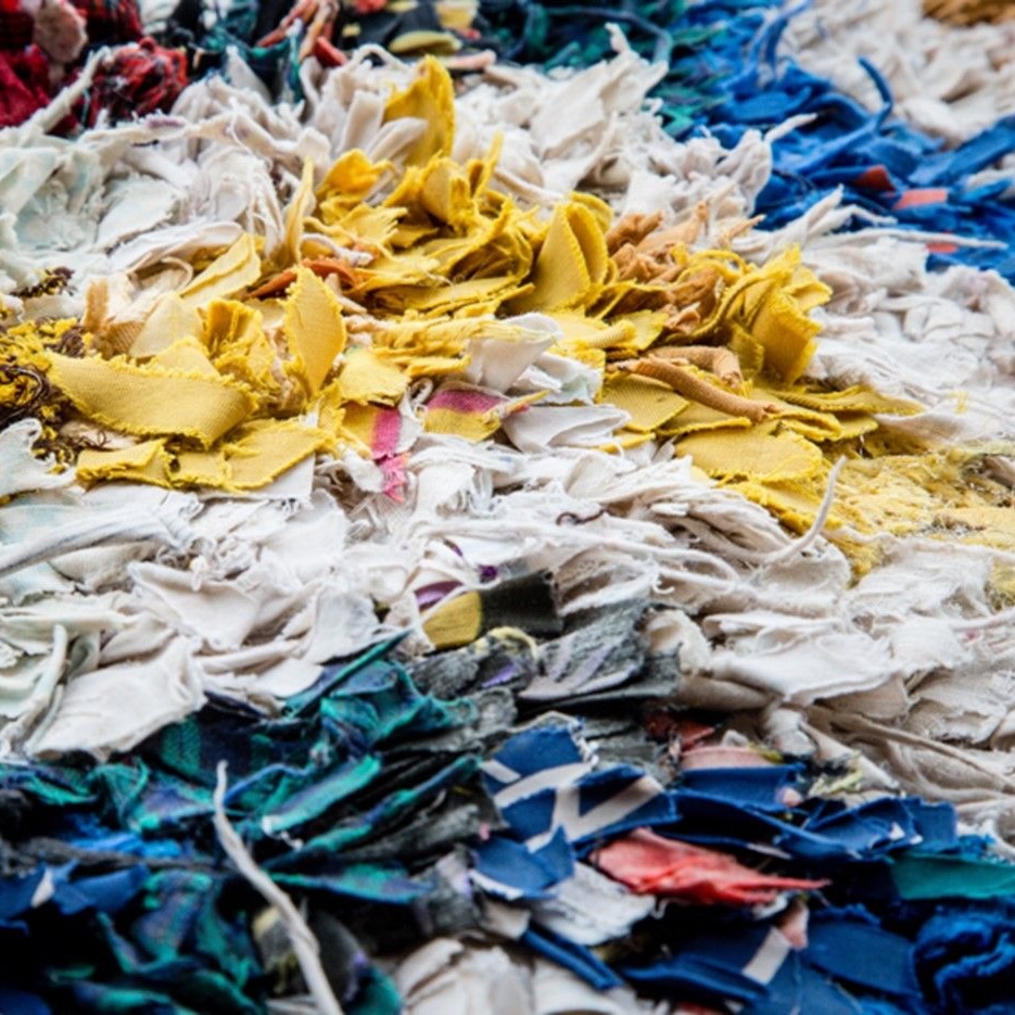 Personne pliant soigneusement un t-shirt, symbole du soin et de la durabilité.